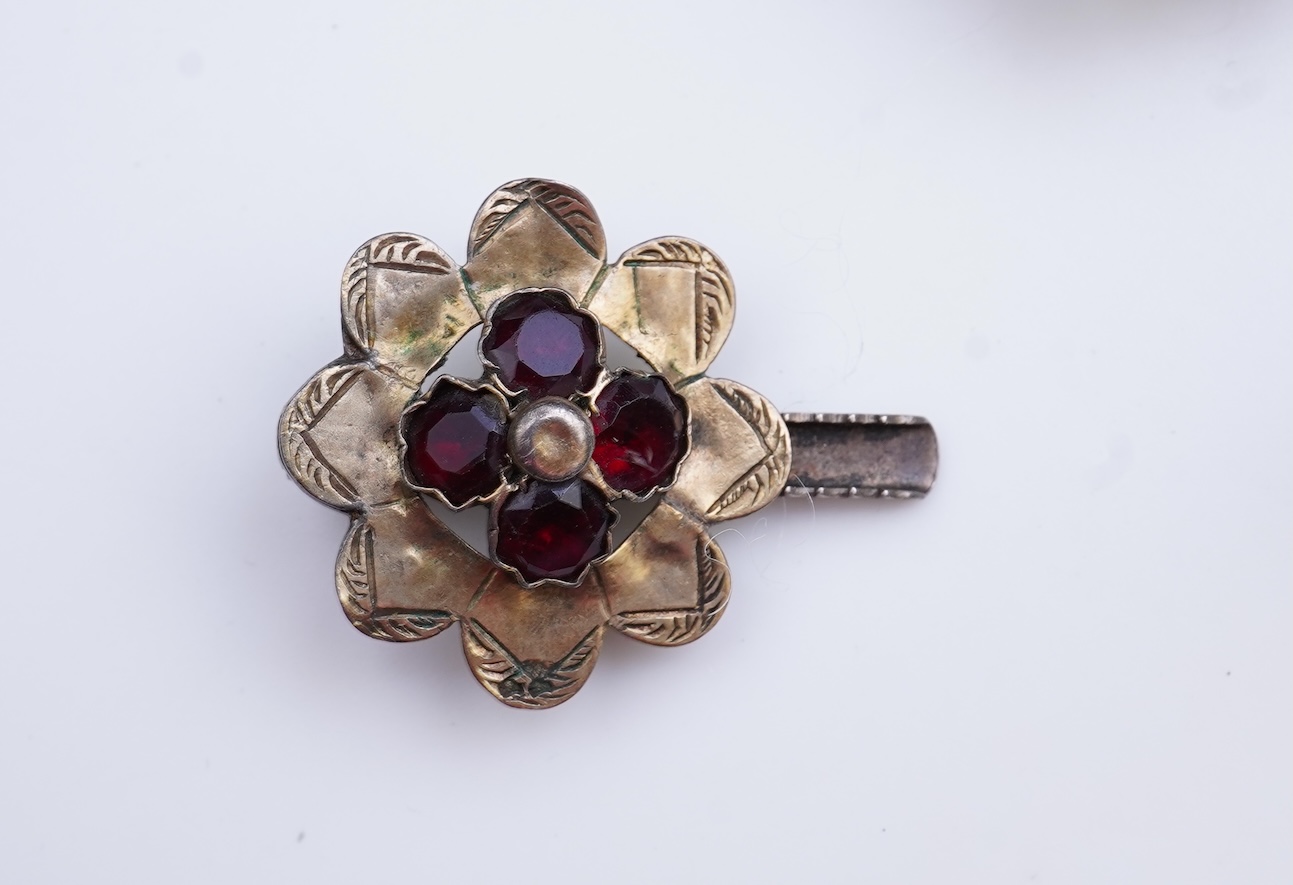 A suite of garnet and paste jewellery, comprising: a brooch, 5cm diameter; a bangle, inner circumference 16cm; two rings, sizes I and M; a pair of earrings, and a single earring, each set with rose-cut garnets; and a pai